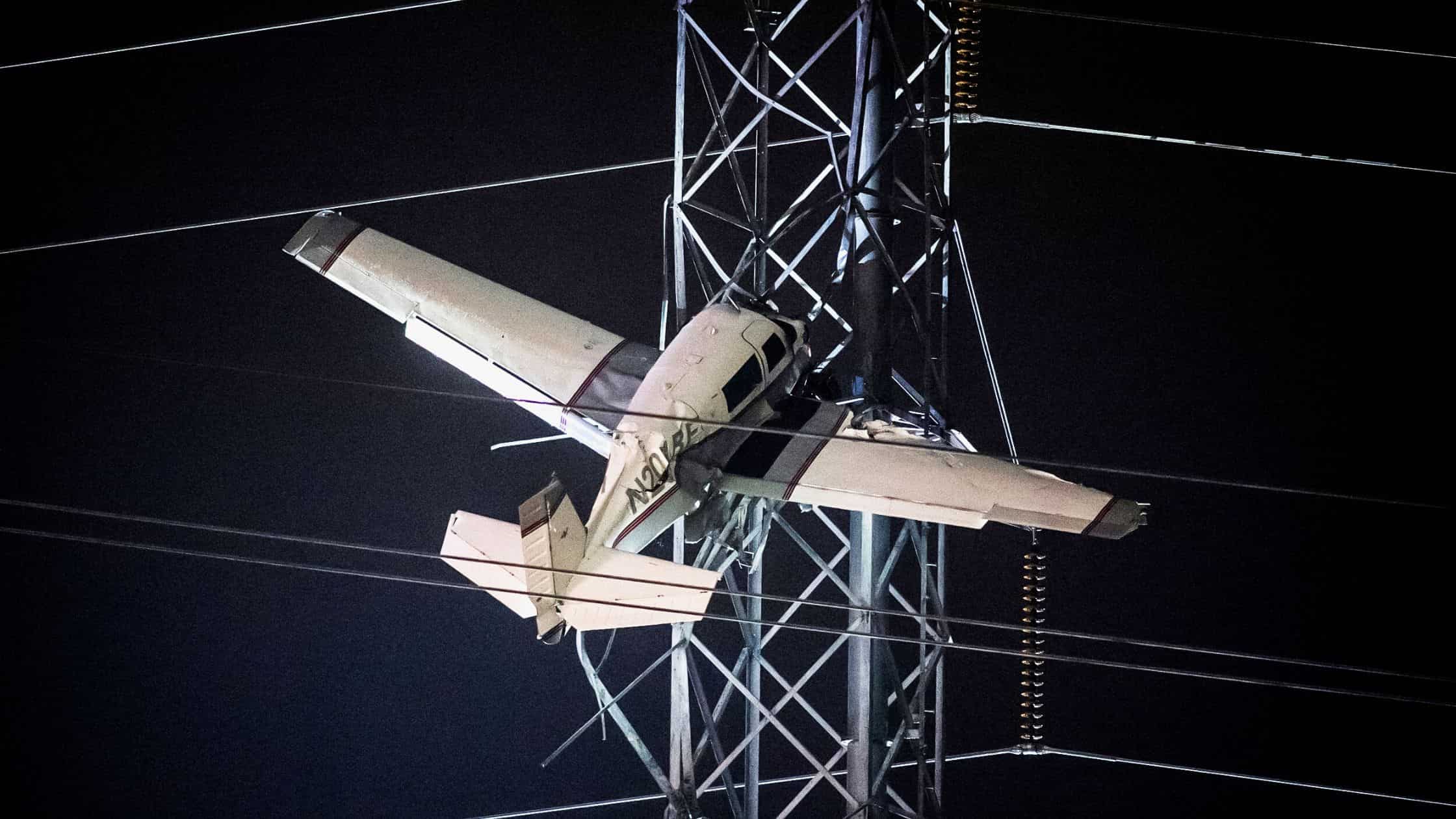 A Small Plane Carrying Two People Hangs 100 Feet In The Air After Colliding With A Power Tower